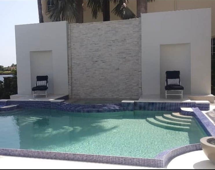 Modern pool with feature wall, Glass tile waterline, wide entry steps